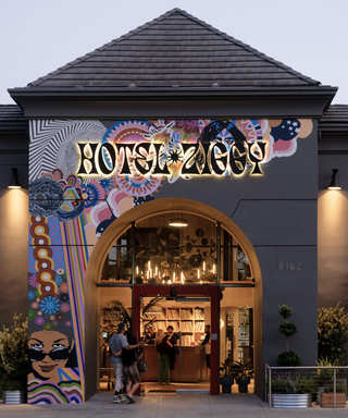 Hotel Ziggy's exterior entrance lit at dusk with a mural partially covering the left hand side